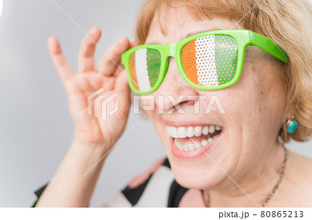 Portrait of smiling elderly woman wearing glasses with ireland flag. Portrait of smiling elderly woman wearing glasses with ireland flag. 80865213
