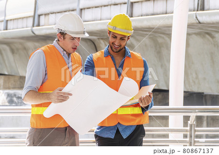 Two engineer or architect with safety helmet planning about building with blueprint. Two engineer or architect with safety helmet planning about building with blueprint. 80867137