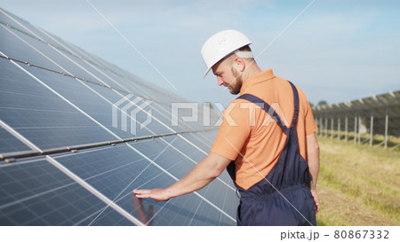Sustainable green energy jobs, solar panel technician working with solar panels. Assistance technical worker in uniform is checking an operation and efficiency performance of photovoltaic solar panels Sustainable green energy jobs, solar panel technician working with solar panels. Assistance technical worker in uniform is checking an operation and efficiency performance of photovoltaic solar panels 80867332
