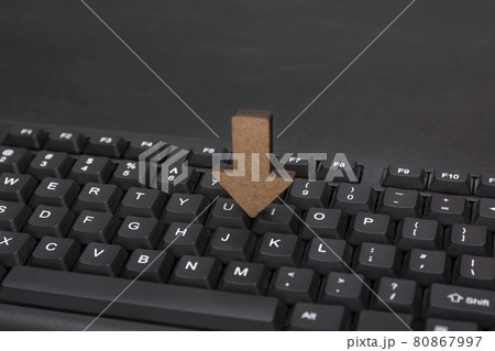 Computer keyboard and wooden arrow to down. Loading data concept 80867997