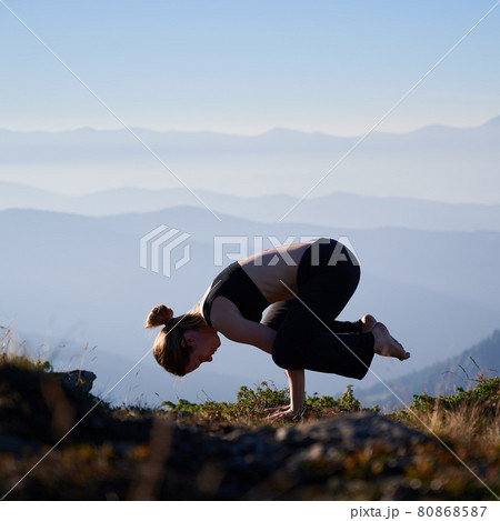 Female is balancing on two arms. 80868587