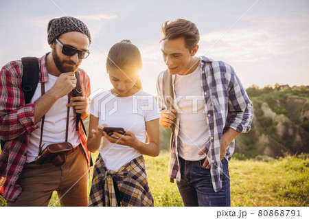 Group of friends, young men and woman walking, strolling together in summer forest, meadow. Active lifestyle, friendship, travel concept 80868791