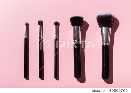 Various make-up brushes on pink background, top view. Cosmetics and beauty concept. Various make-up brushes on pink background, top view. Cosmetics and beauty concept. 80869769