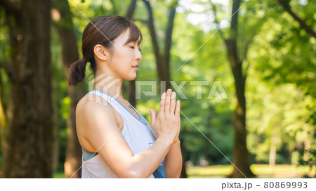 自然公園の中でヨガを行いリフレッシュする女性の写真素材