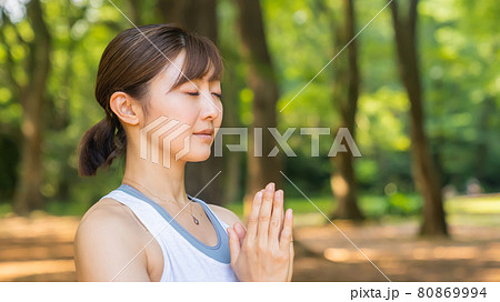 自然公園の中でヨガを行いリフレッシュする女性 自然公園の中でヨガを行いリフレッシュする女性 80869994