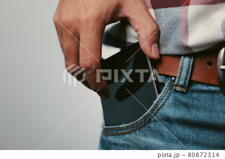 Mobile phone in denim jean pocket 80872314