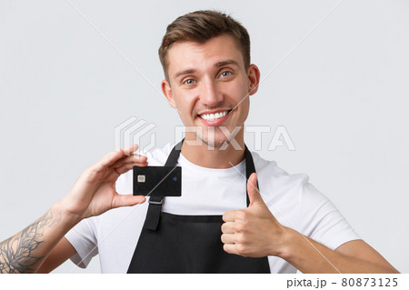 Cafe and restaurants, coffee shop owners and retail concept. Cheerful handsome salesman, store clerk in black apron showing thumbs-up in approval, recommend paying for credit card Cafe and restaurants, coffee shop owners and retail concept. Cheerful handsome salesman, store clerk in black apron showing thumbs-up in approval, recommend paying for credit card 80873125