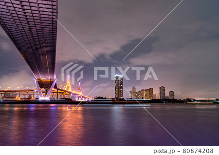 Purple led light under the bridge over the river On a cloudy day in the sky. Bhumibol Bridge, Samut Prakan, Thailand Purple led light under the bridge over the river On a cloudy day in the sky. Bhumibol Bridge, Samut Prakan, Thailand 80874208
