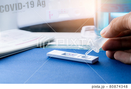 Hand holding sample tube and drops in the test device of covid 19 antigen self-test. Antigen test kit for detection of coronavirus infection. Rapid antigen test. Coronavirus diagnosis. Medical device. 80874348