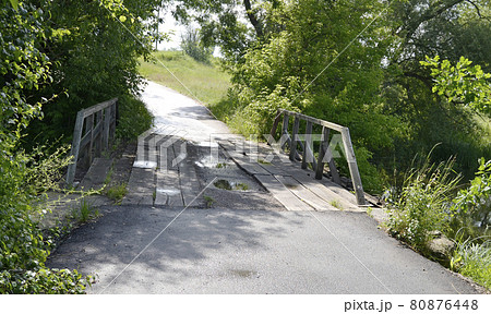 Beautifully standing old wooden bridge over river in colored background 80876448