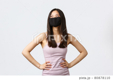 Covid-19, social distancing quarantine and leisure concept. Stylish asian woman in face mask and evening dress, enjoying party, celebrating holidays, looking away dreamy Covid-19, social distancing quarantine and leisure concept. Stylish asian woman in face mask and evening dress, enjoying party, celebrating holidays, looking away dreamy 80878110