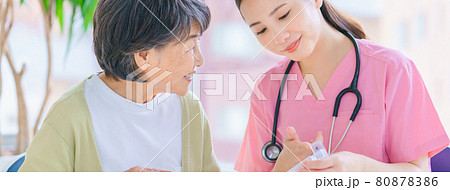 薬ケースの説明をする介護スタッフ 80878386