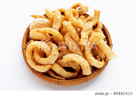 Fried crispy pork rinds in bamboo basket on white background. 80882415