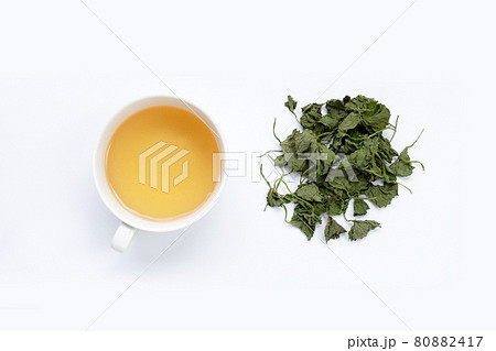Cup of tea with gotu kola dried leaves on white background. 80882417