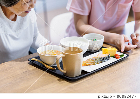 食事をするシニア女性と介護士　撮影協力：中央工学校附属日本語学校 80882477