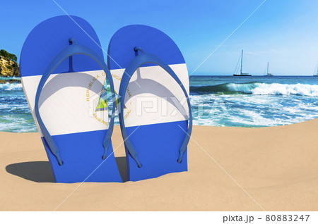 Flip flops with Nicaraguan flag on the beach. Nicaragua resorts, vacation, tours, travel packages concept. 3D rendering Flip flops with Nicaraguan flag on the beach. Nicaragua resorts, vacation, tours, travel packages concept. 3D rendering 80883247
