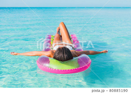 Summer luxury vacation relaxation bikini woman sunbathing lying down on air mattress floating on blue turquoise water paradise beach relaxing sunbathing in Caribbean. 80885190