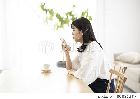 リビングで電話をする若い女性 80885387