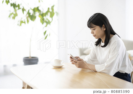 リビングでスマホを操作する若い女性 80885390