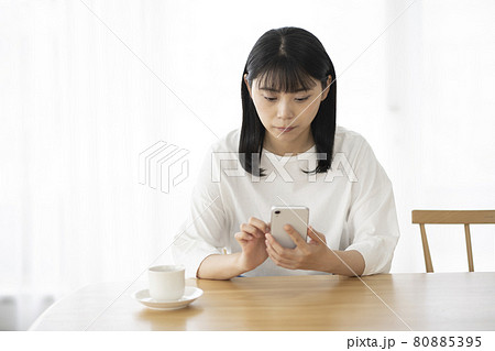 リビングでスマホを操作する若い女性 80885395