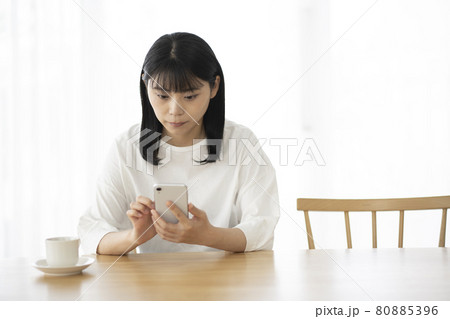リビングでスマホを操作する若い女性 80885396