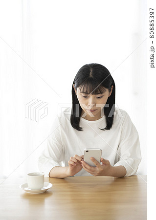 リビングでスマホを操作する若い女性 80885397