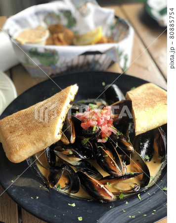 Close up of freshly cooked mussles in a plate with ingredients Close up of freshly cooked mussles in a plate with ingredients 80885754