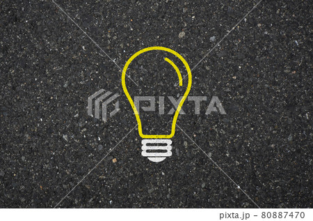 アスファルト道路に閃きイメージの電球標識の背景素材 80887470