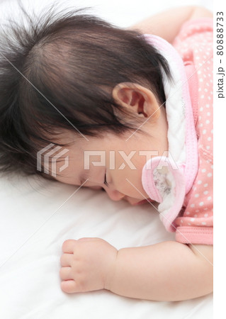 うつ伏せで寝る女の子の赤ちゃんの写真素材