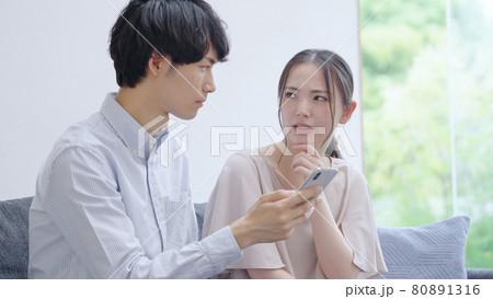 スマホを見る若い夫婦・カップル スマホを見る若い夫婦・カップル 80891316