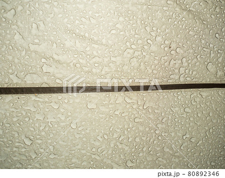 Big rain drops on the surface of a tourist tent taken close-up from inside 80892346