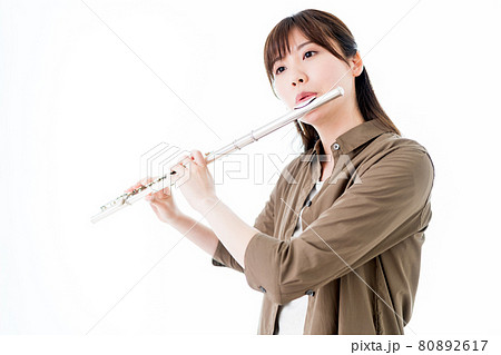 カジュアルな装いでフルートを演奏する女性 80892617
