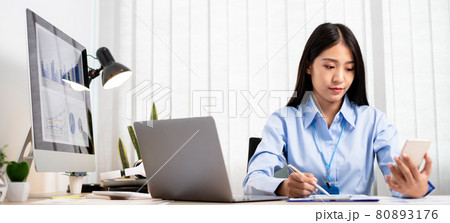 Asian women sit at their desks and calculate financial graphs showing results about their investments, plan a successful business growth process 80893176