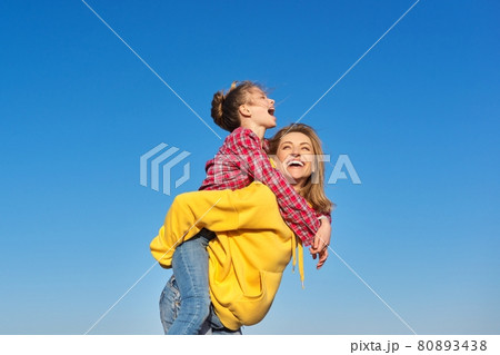 Happy mom and daughter child on seashore, relaxing on the sandy beach, autumn winter spring season 80893438