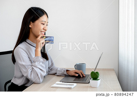 The Asian businesswoman's hand is holding a credit card and using a laptop for online shopping The Asian businesswoman's hand is holding a credit card and using a laptop for online shopping 80894247