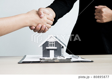 Businessmen and brokers real estate agents shake hands after completing negotiations to buy houses insurance and sign contracts. Home insurance concept 80895877