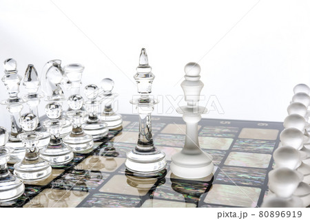 glass chess pieces is standing on board in white 80896919