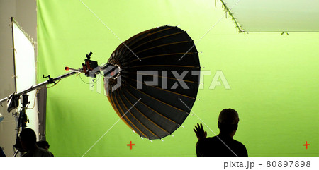 Video production behind the scenes. Making of TV commercial movie that film crew team lightman and cameraman working together with film director in studio. film production concept. Silhouette style. 80897898