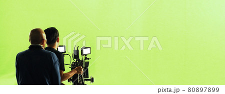 Video production behind the scenes. Making of TV commercial movie that film crew team lightman and cameraman working together with film director in studio. film production concept. Silhouette style. 80897899