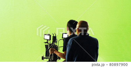 Video production behind the scenes. Making of TV commercial movie that film crew team lightman and cameraman working together with film director in studio. film production concept. Silhouette style. 80897900