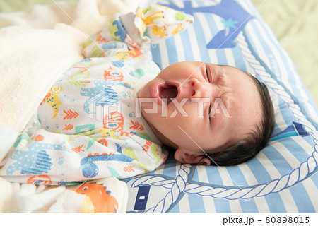 Top view of cute little Asian baby yawning before sleep on the bed Top view of cute little Asian baby yawning before sleep on the bed 80898015