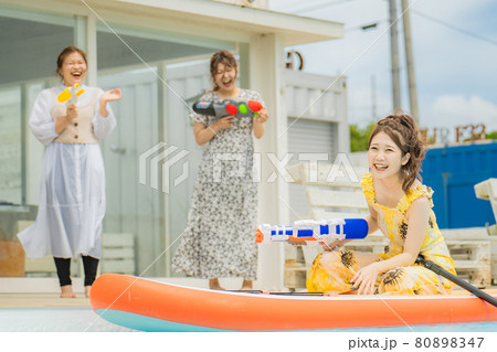 プールで水鉄砲で遊ぶ女性達 80898347
