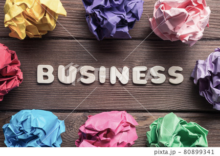 Business word colorful crampled paper ball placed in circle on wooden table Business word colorful crampled paper ball placed in circle on wooden table 80899341