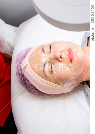Transparent mask-film on the face of a woman, a visit to a beautician, facial care. 80901459