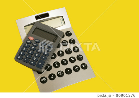 two calculators on a yellow surface. office accessories. school 80901576