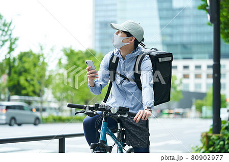 都会で自転車に乗りデリバリーをする男性 80902977