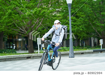 都会で自転車に乗りデリバリーをする男性 都会で自転車に乗りデリバリーをする男性 80902994