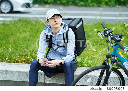 都会で自転車に乗りデリバリーをする男性 都会で自転車に乗りデリバリーをする男性 80903003