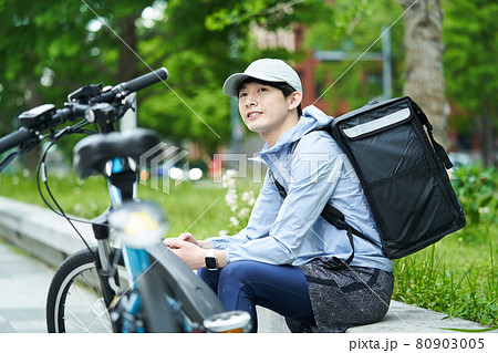 都会で自転車に乗りデリバリーをする男性 80903005