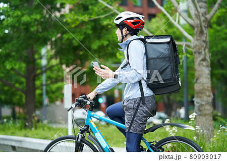 都会で自転車に乗りデリバリーをする男性 80903017